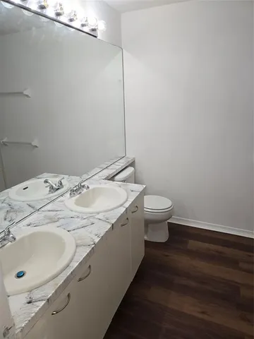 a bathroom with a granite countertop sink a toilet and a mirror