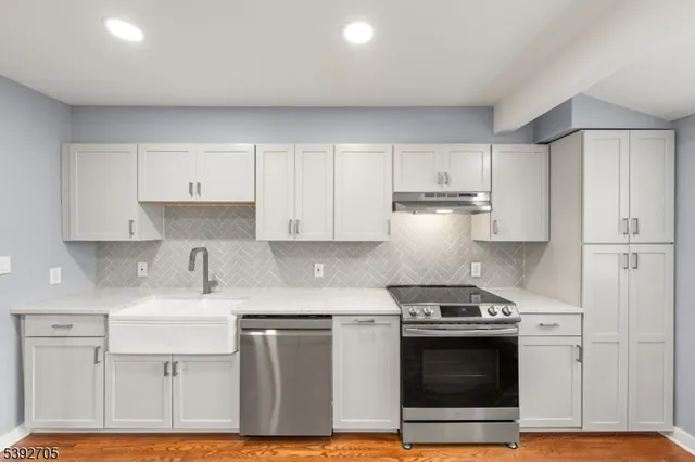 a kitchen with stainless steel appliances granite countertop a stove a sink and a refrigerator