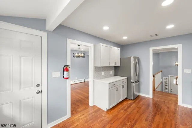 a kitchen with stainless steel appliances a refrigerator and a wooden floor