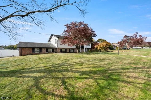 a front view of a house with a garden and trees