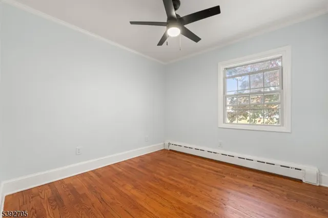 an empty room with a window and a ceiling fan