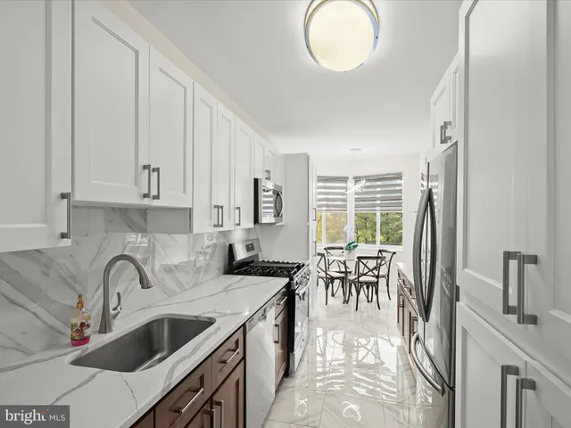 a kitchen with stainless steel appliances granite countertop a sink stove and cabinets