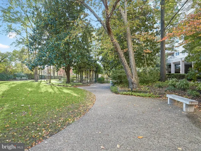 a view of a brick house with a big yard and large trees