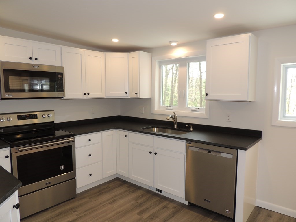 214 Wilbraham Road Monson, MA 01057 - Photo 10 of 38 a kitchen with granite countertop white cabinets appliances a sink and a window