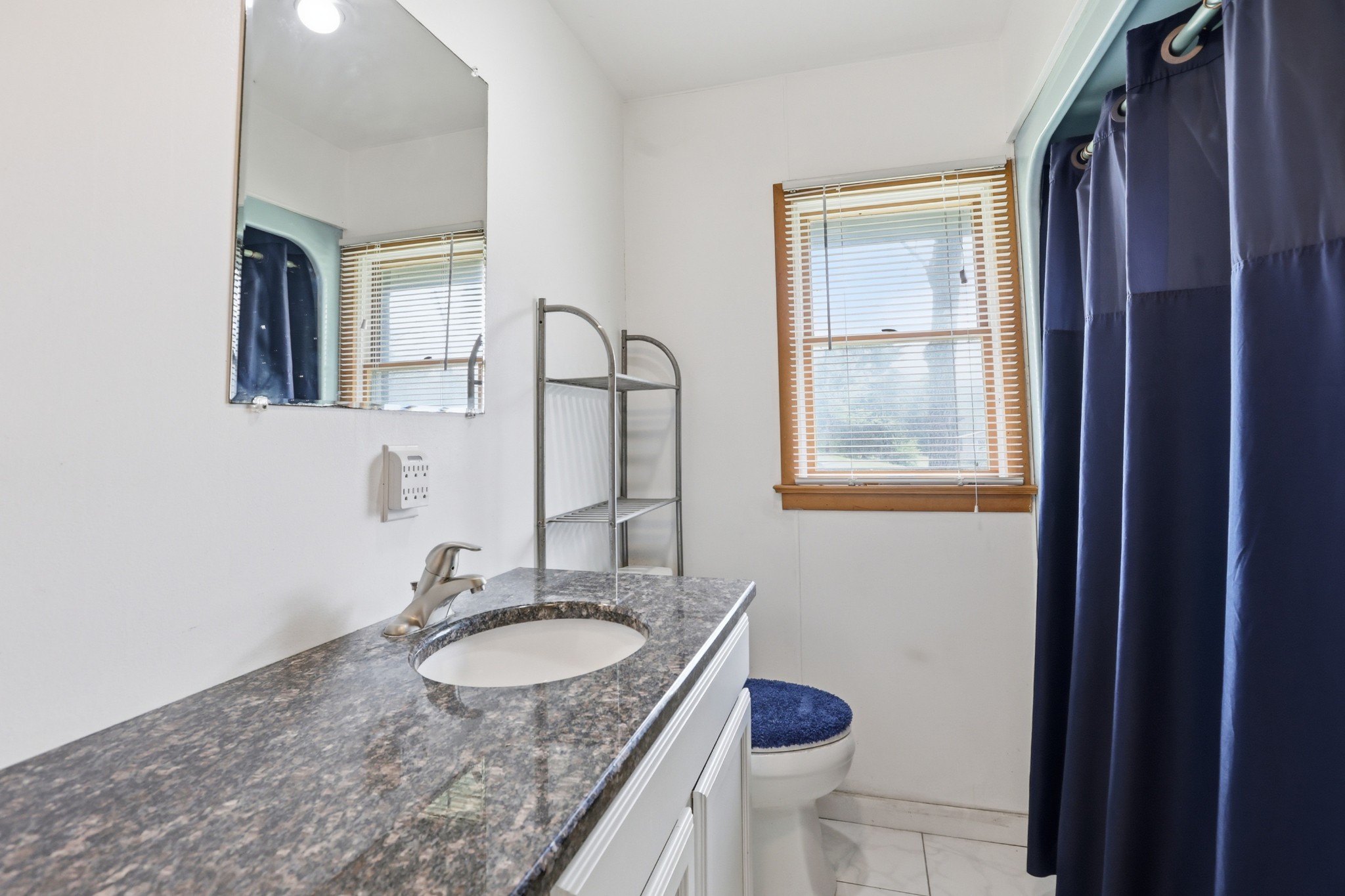 1071 Simms Heights Road Kingston Springs, TN 37082 - Photo 25 of 38 a bathroom with a granite countertop sink a toilet and a mirror