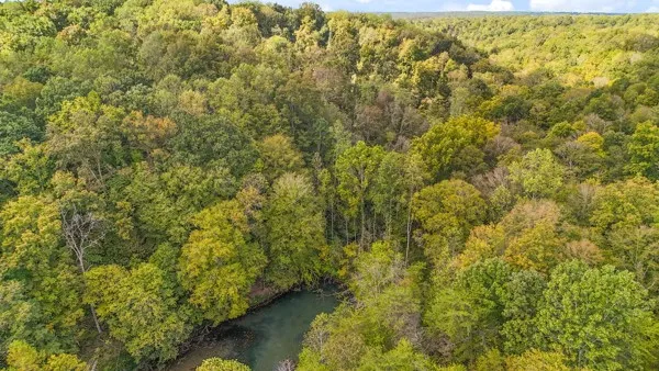 a view of a hallway with wooden floor a bedroom and a bed