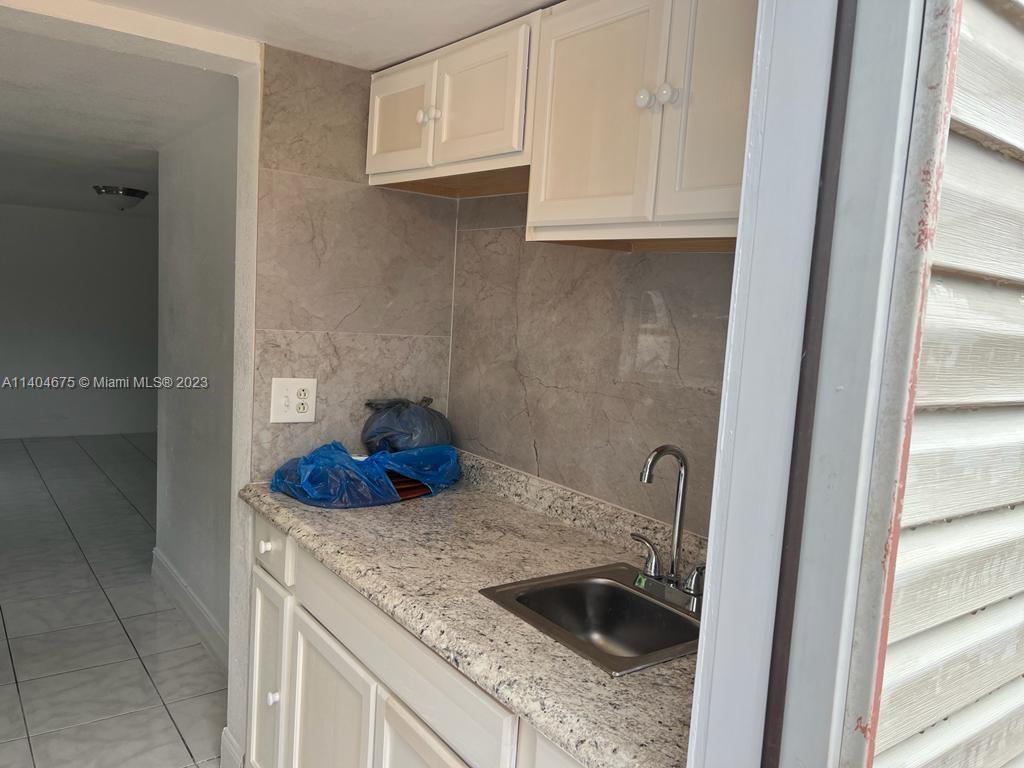 1329 Sunrise Road West Palm Beach, FL 33406 - Photo 21 of 28 a kitchen with a sink and a refrigerator