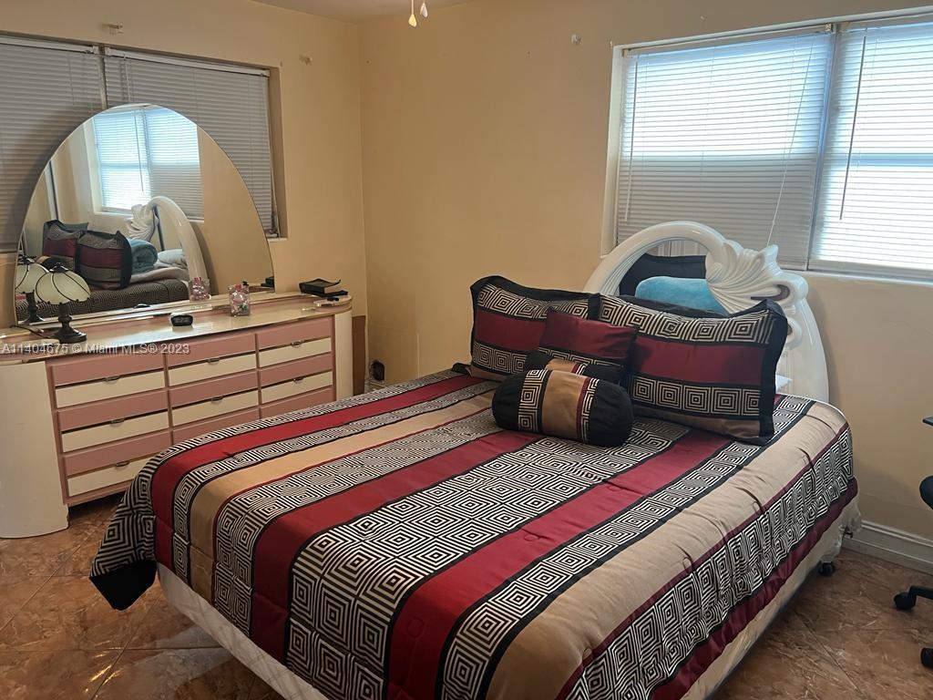 1329 Sunrise Road West Palm Beach, FL 33406 - Photo 9 of 28 a bedroom with a bed a mirror and window