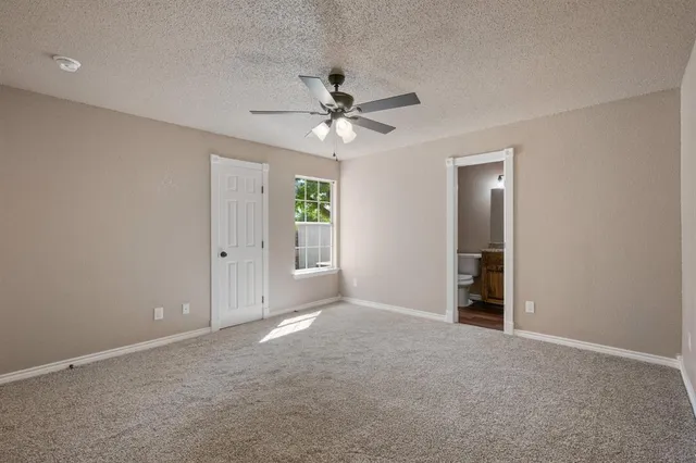 an empty room with closet and a ceiling fan