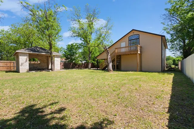 a front view of house with yard and trees in the background
