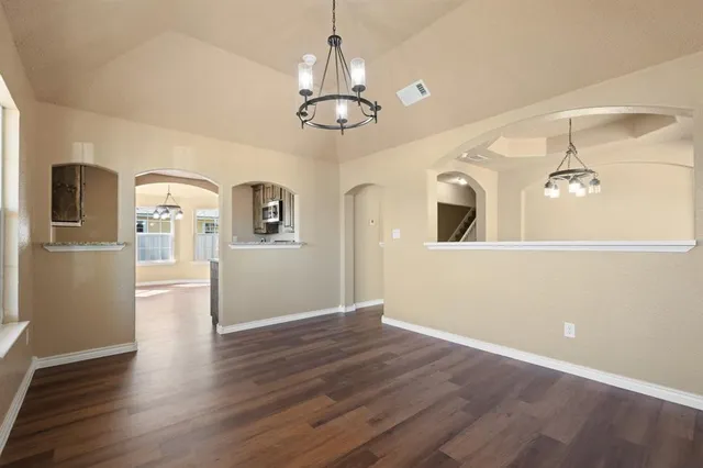 a view of a kitchen with a refrigerator wooden floor and a ceiling fan