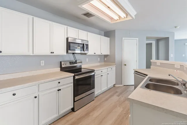 a kitchen that has a sink and a stove top oven