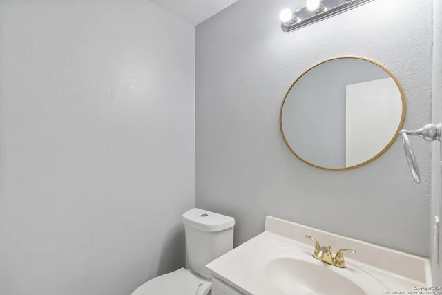 a bathroom with a toilet a sink and mirror