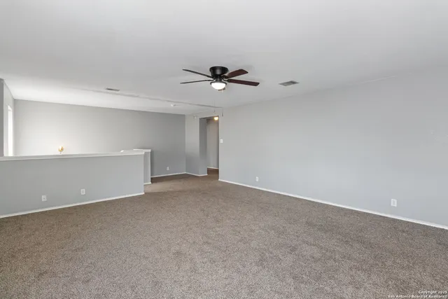 a view of a room with a ceiling fan and window