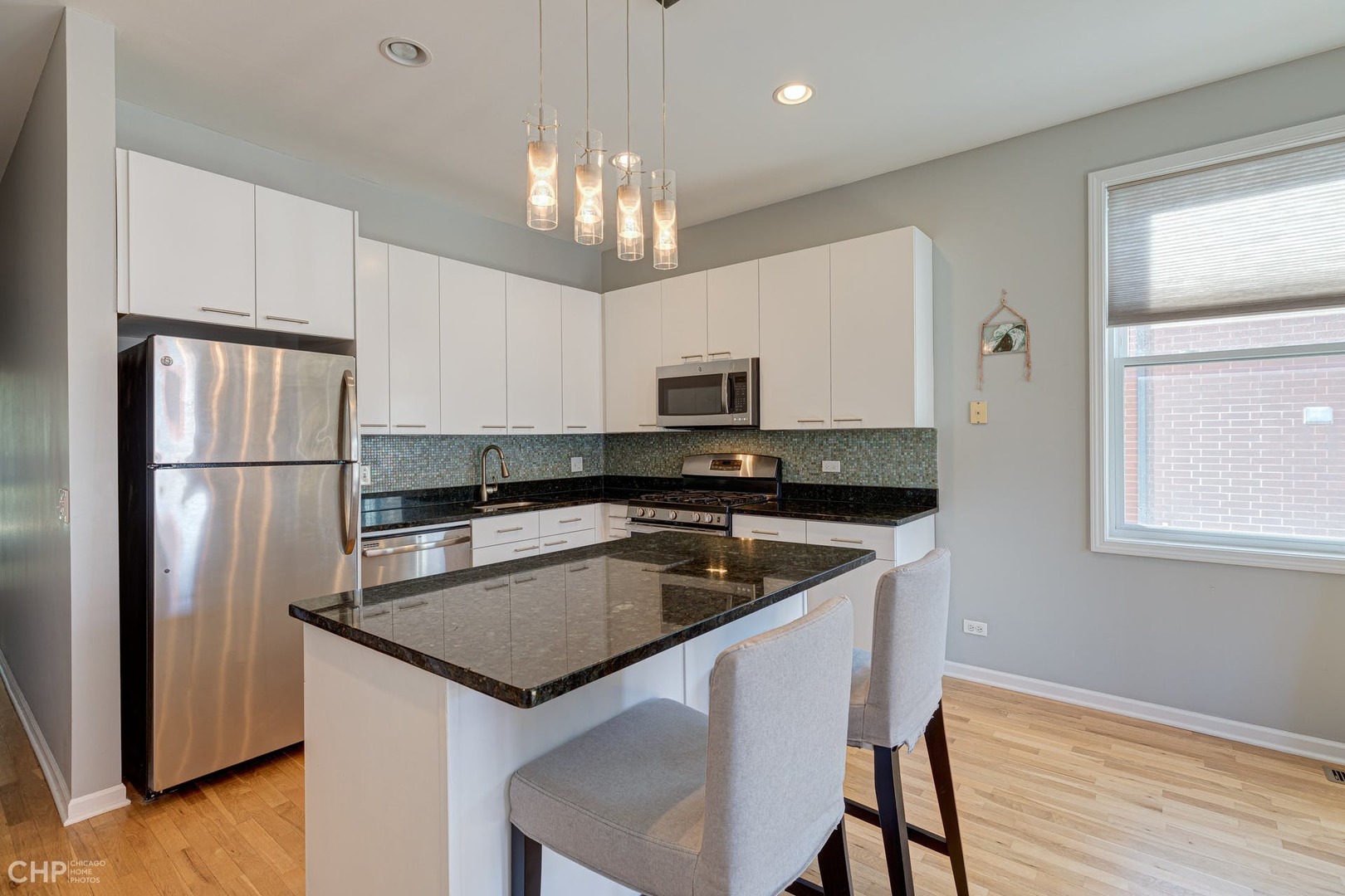 2127 West Rice Street, Unit 3W Chicago, IL 60622 - Photo 9 of 17 a kitchen with granite countertop a refrigerator oven a sink dishwasher and white cabinets with wooden floor