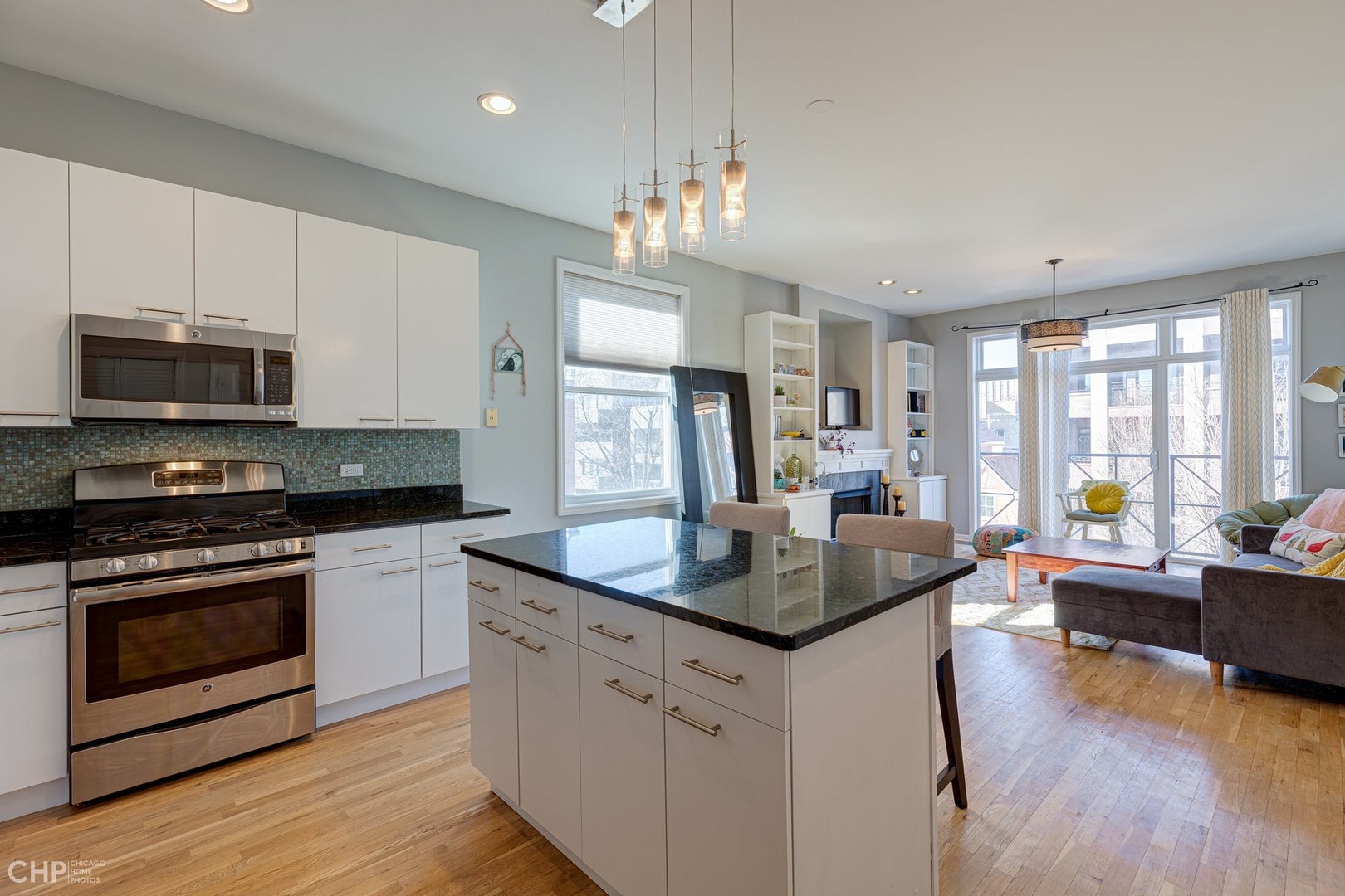2127 West Rice Street, Unit 3W Chicago, IL 60622 - Photo 10 of 17 a kitchen with stainless steel appliances granite countertop a stove top oven a sink dishwasher a dining table and chairs with wooden floor