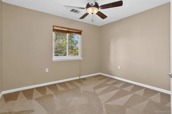 an empty room with chandelier fan