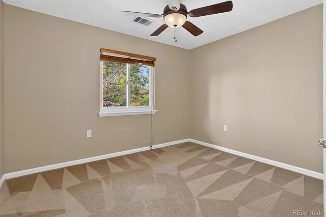 an empty room with chandelier fan