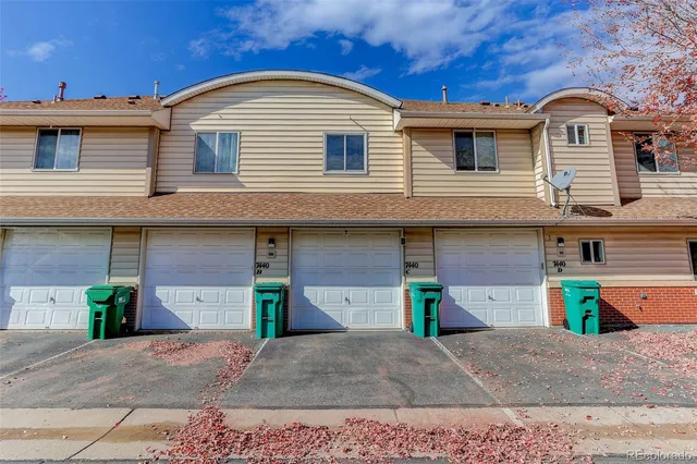 a view of a house with a yard and large tree