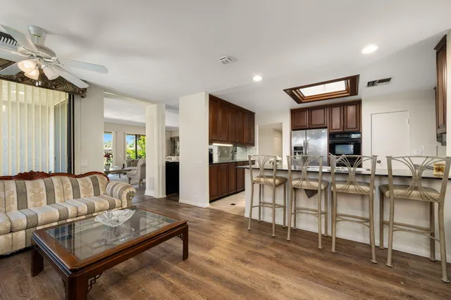 a kitchen with stainless steel appliances granite countertop a refrigerator a sink a stove top oven and a sink