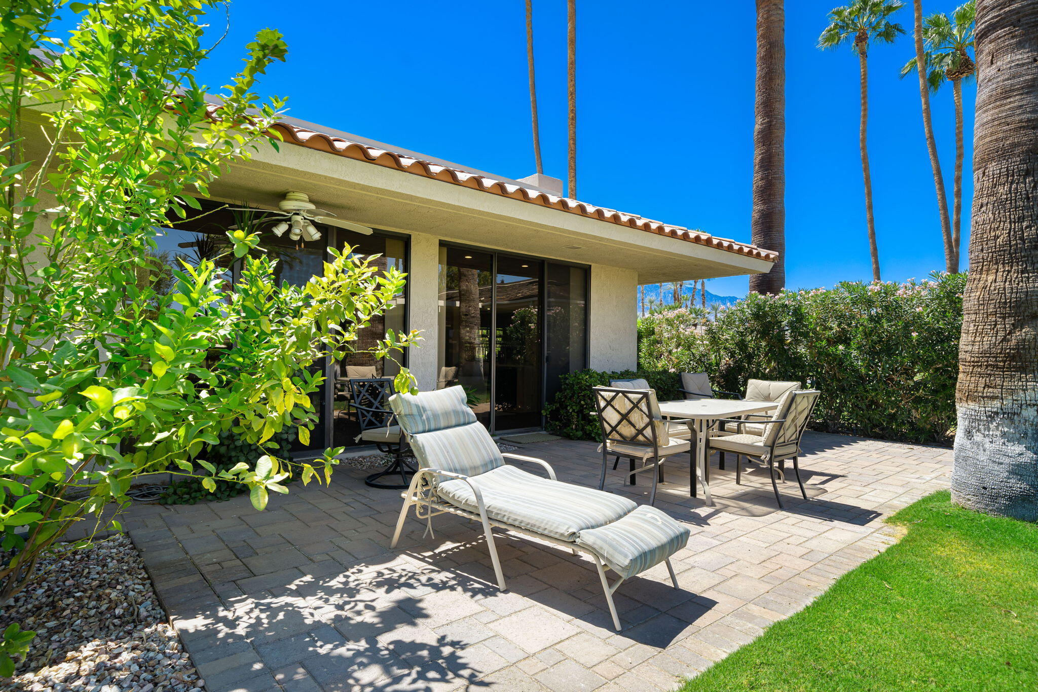140 Columbia Drive Rancho Mirage, CA 92270 - Photo 32 of 42 a view of a patio with table and chairs and potted plants