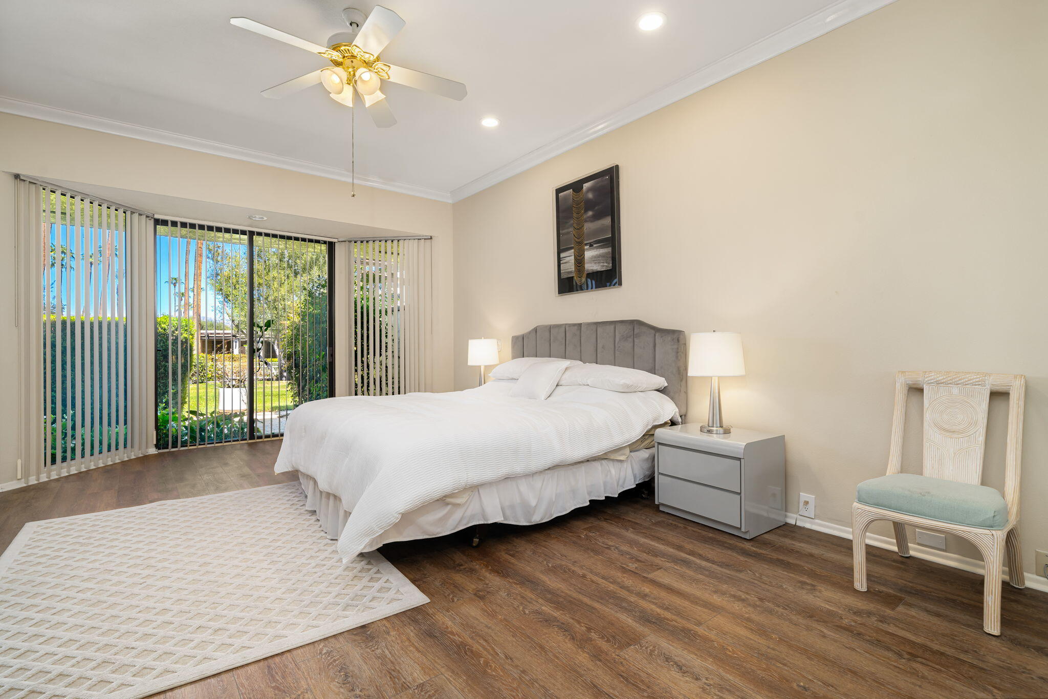 140 Columbia Drive Rancho Mirage, CA 92270 - Photo 34 of 42 a spacious bedroom with a bed and a chandelier
