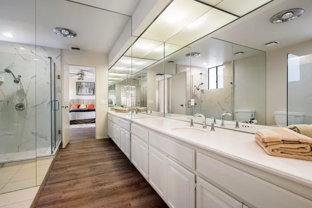a bathroom with a double vanity sink a mirror and shower