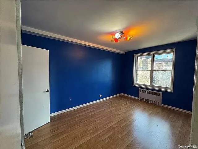 an empty room with wooden floor and windows in it