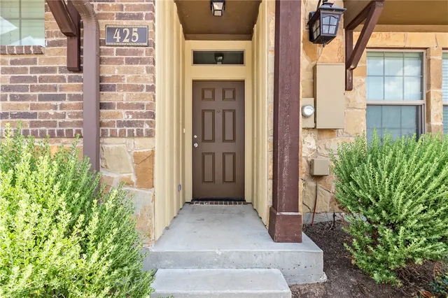 a view of a brick house with a large window and front door