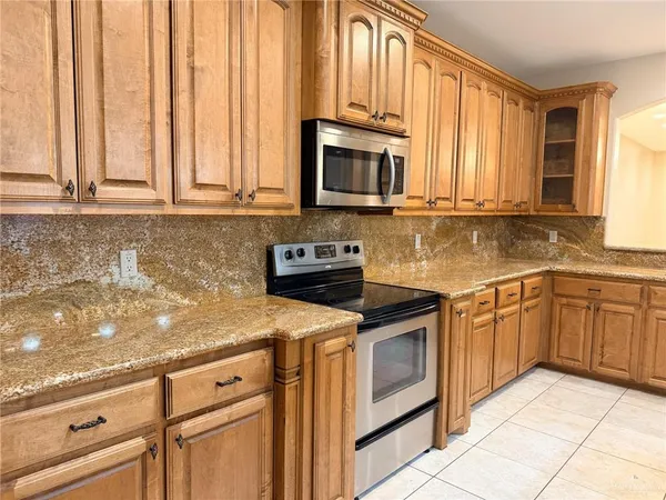 a kitchen with stainless steel appliances granite countertop white cabinets a sink and a oven