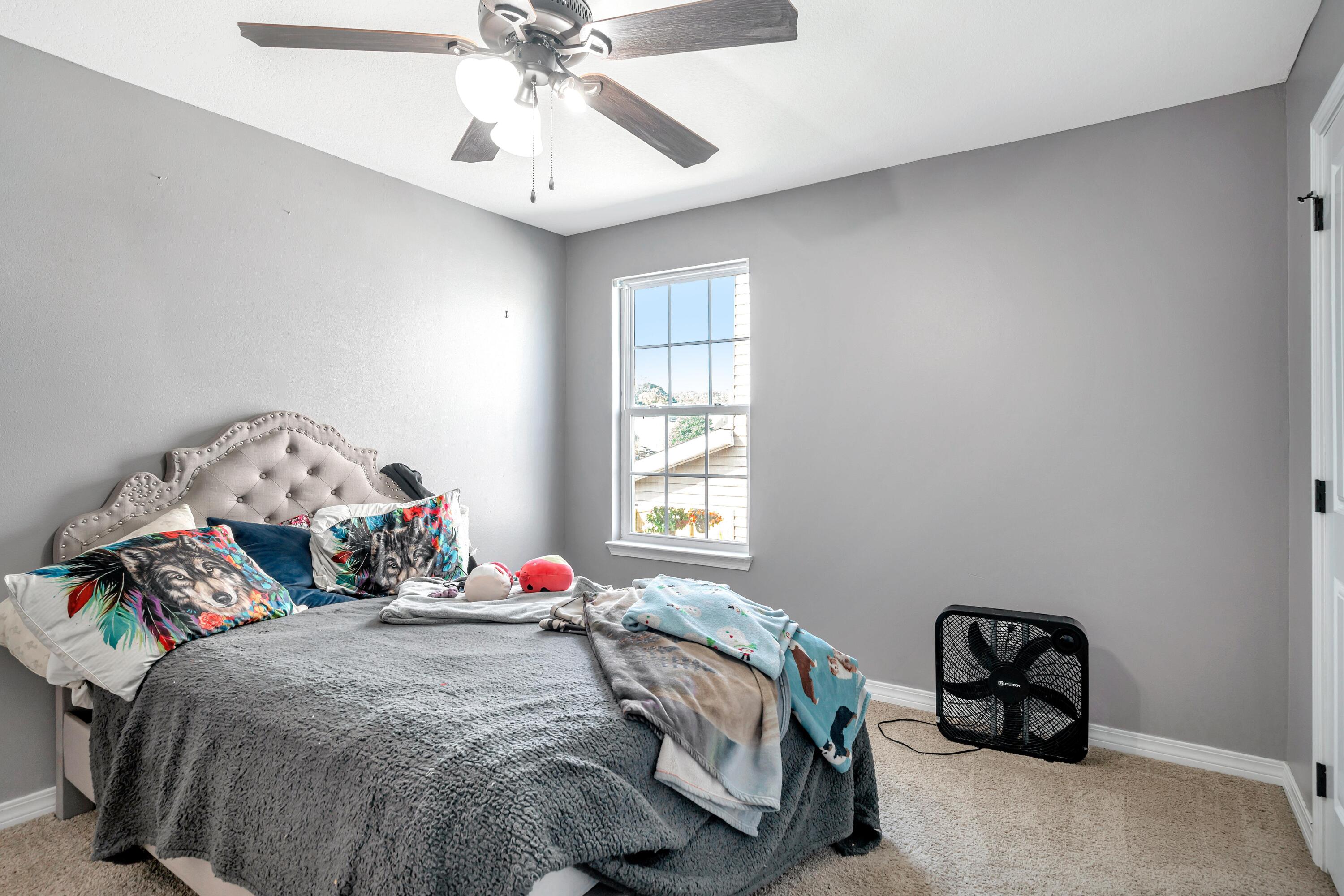 505 Eisenhower Drive Crestview, FL 32539 - Photo 19 of 39 a bedroom with a bed and a chandelier