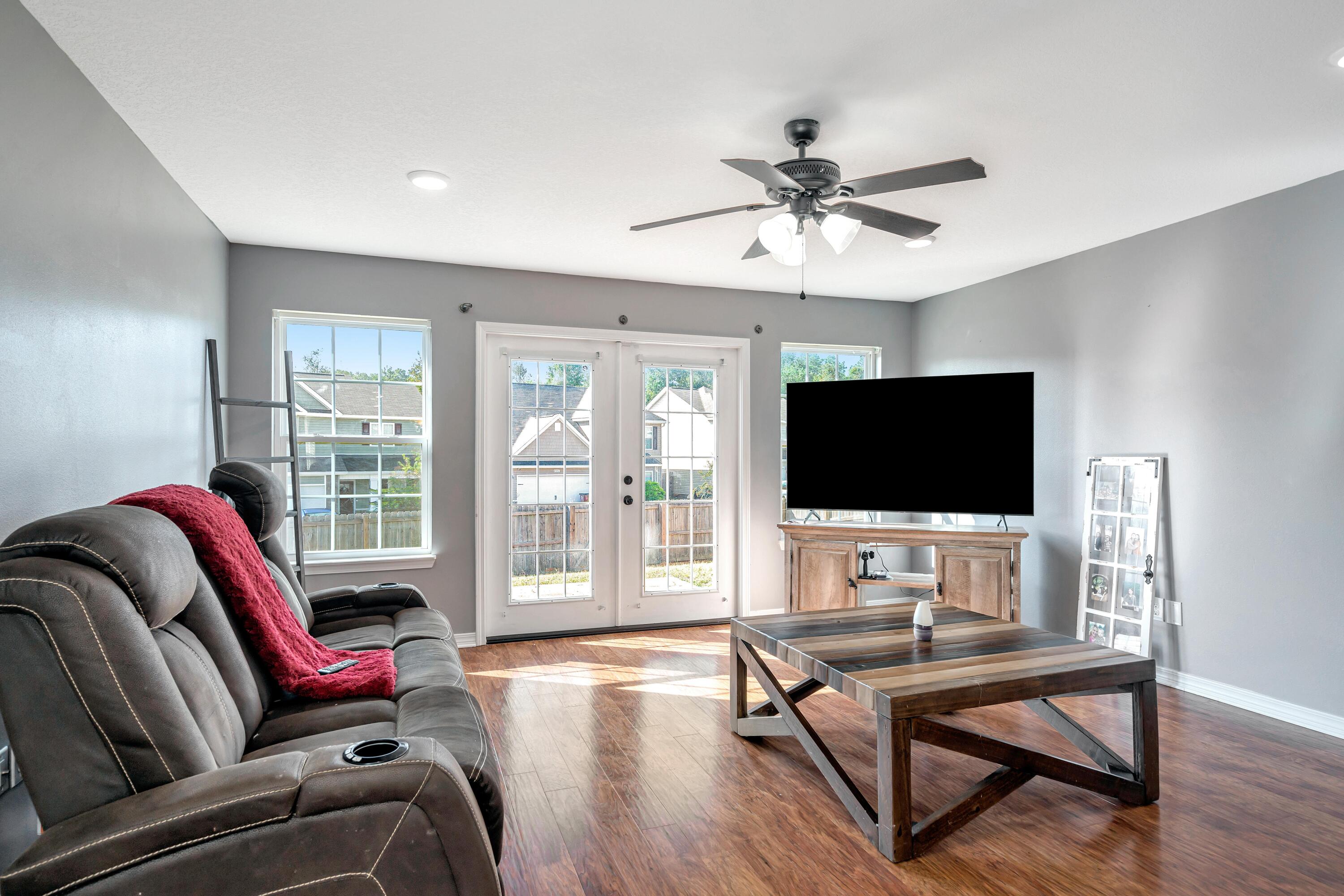 505 Eisenhower Drive Crestview, FL 32539 - Photo 8 of 39 a living room with furniture a flat screen tv and wooden floor