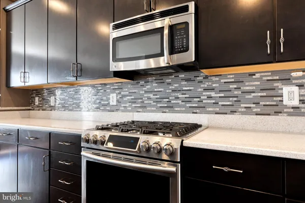 a kitchen with stainless steel appliances granite countertop a sink stove and microwave