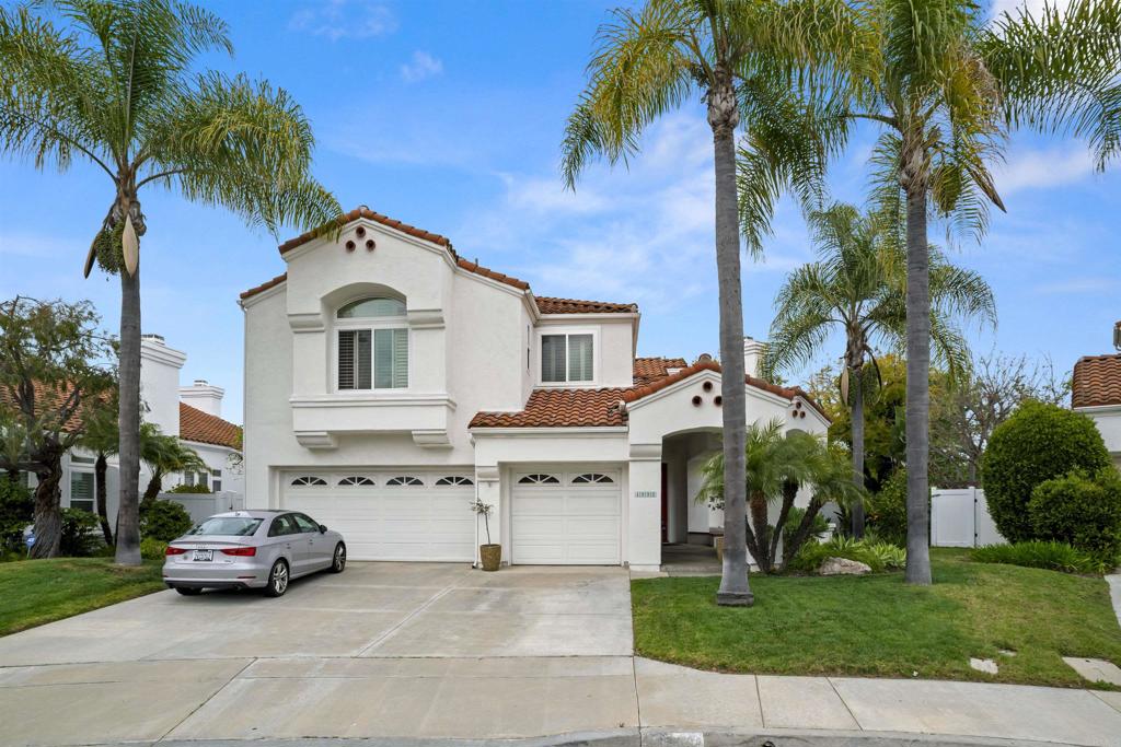 a car parked in front of white house with a small yard