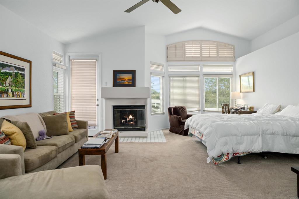 4992 Lassen Drive Oceanside, CA 92056 - Photo 14 of 27 a spacious bedroom with a bed a couch and a fireplace