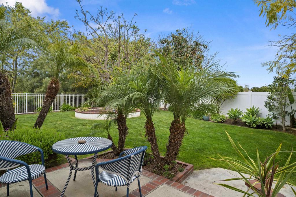 4992 Lassen Drive Oceanside, CA 92056 - Photo 24 of 27 a view of a backyard with table and chairs potted plants and palm tree