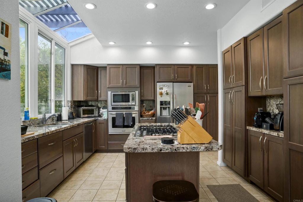 4992 Lassen Drive Oceanside, CA 92056 - Photo 7 of 27 a kitchen with stainless steel appliances granite countertop a sink stove and refrigerator