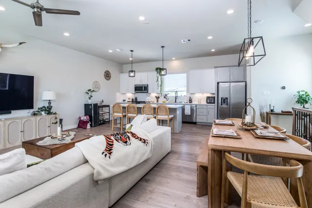 a kitchen with stainless steel appliances a sink a stove a refrigerator cabinets and wooden floor