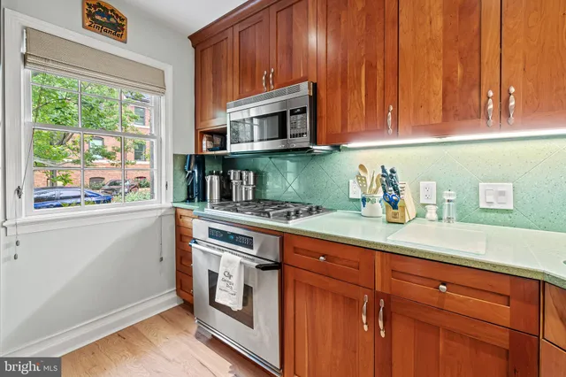 a kitchen with stainless steel appliances granite countertop wooden cabinets a sink and a window