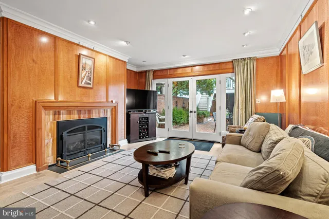 a living room with furniture a fireplace and a large window