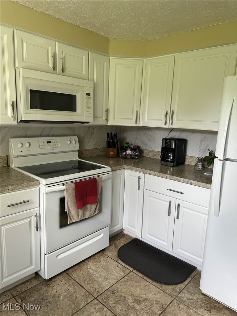 558 Frost Road Streetsboro, OH 44241 - Photo 8 of 32 All White cabinets with all white appliances included ornamental molding, pattern flooring, backsplash. great sunlight from the window looks out to the spacious back yard