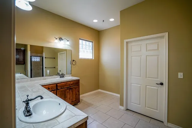a bathroom with a sink a mirror and a shower
