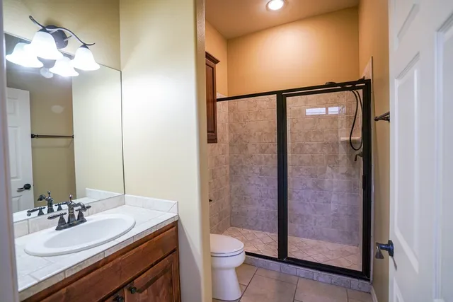 a bathroom with a granite countertop sink toilet and shower