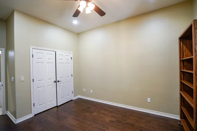 an empty room with wooden floor and cabinet