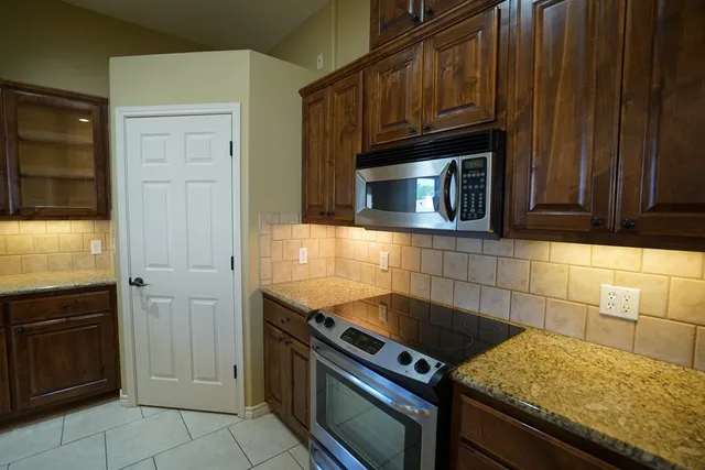 a kitchen with granite countertop cabinets and steel stainless steel appliances