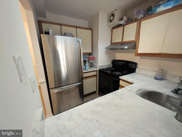 a kitchen with a refrigerator sink and cabinets