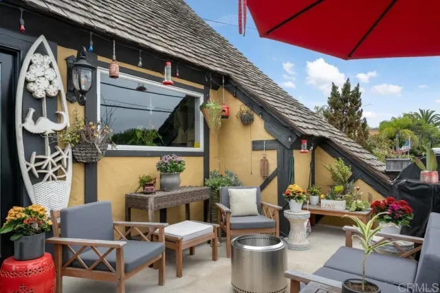 a roof deck with table and chairs potted plants and a large tree