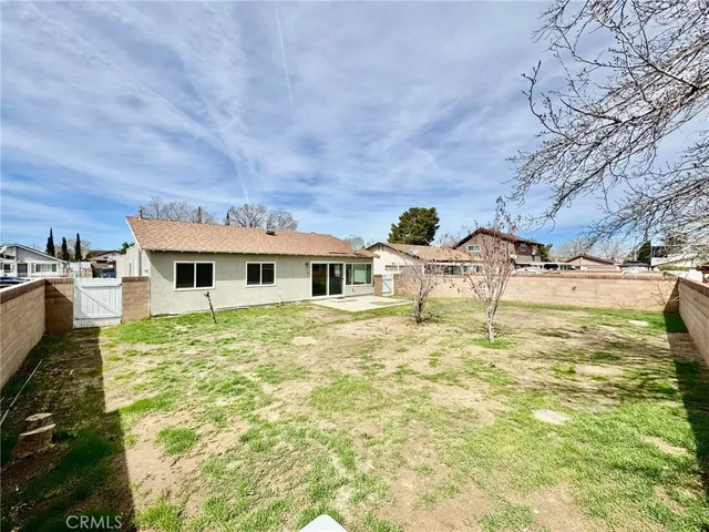 a backyard of a house with table and chairs