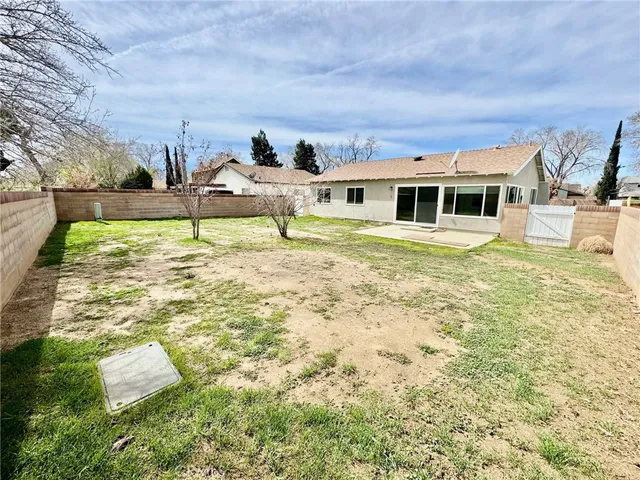 a backyard of a house with table and chairs