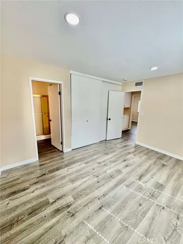an empty room with wooden floor and bathroom